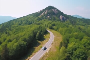 Fototapeta na wymiar Car driving on two-lane asphalt freeway to rocky peak of forestry mountain