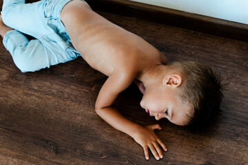 Skinny sad little boy lying on the floor - Powered by Adobe