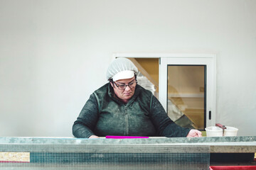Working woman at work in front of a conveyor belt