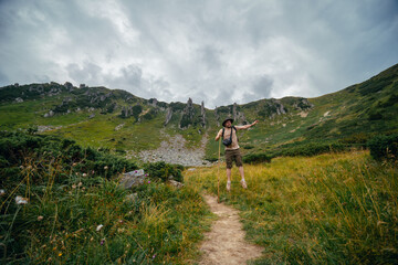 A man funny bounces, jumps, has fun, on the path leading to the top of Mount Spitsy, Carpathian Mountains, nature of Ukraine. Tourism and active lifestyle