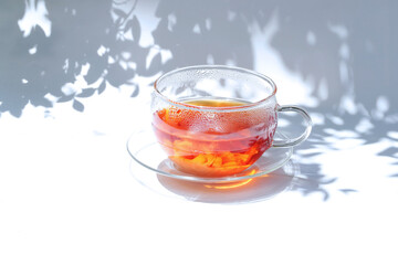 明るい陽射しとティーカップと葉っぱの影