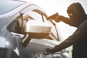 Thieves are using guns to rob a car, threatening a woman with car keys.