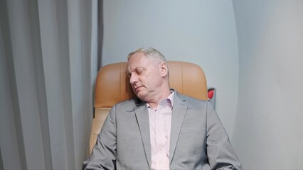 Close up of middle aged caucasian man passenger sleeping on comfortable seat while travel by aircraft