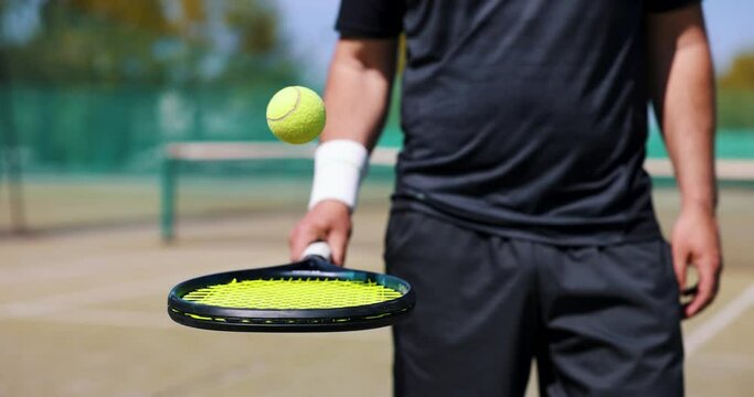 tennis player bounce the ball on racket at outdoor game court. slow motion