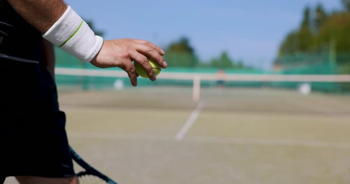 tennis player bounce the ball before a serve at outdoor game court. slow motion