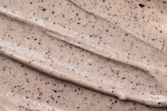 Face cream coffee scrub texture. Cosmetic exfoliation face or body cream. Handmade coffee scrub for body care.