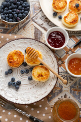 Overhead view of cheese pancalkes with jam and berries breakfast food