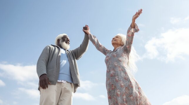 Elderly multiracial couple holding hands and soaring