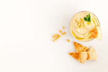 Homemade chickpea hummus in bowl with oil and herbs