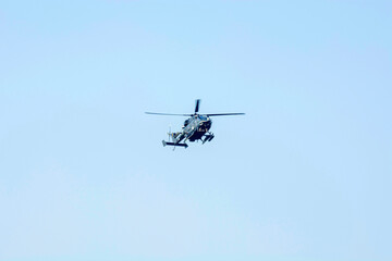 Fototapeta na wymiar Combat helicopter is flying against isolated blue sky. Combat helicopter attack enemy.