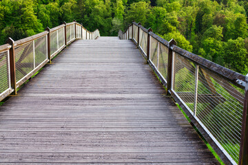Fototapeta na wymiar Wooden Bridge Leading to Green Hills