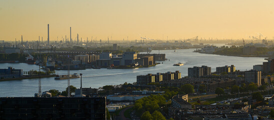 Aerial view of the New Meuse river at sunset, west of Rotterdam in the Netherlands - Large number of smokestacks in Europoort, the harbour of La Haye in the North Sea