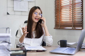 Business concept, Businesswoman is talking financial data with partner on smartphone at office