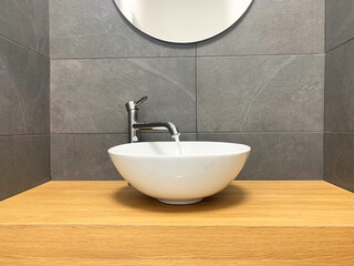 Fototapeta premium chromed taps in black and white modern minimal bathroom with wood plan. Open water flow