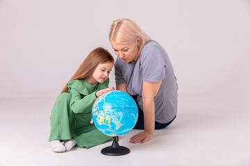 little girl learning geography with mom. Mother and daughter looking at a globe
