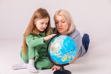 Fototapeta premium Go on an adventure. Happy family preparing for the journey. Mom and daughter study the map and choose a route of travel.