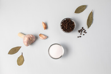 Salt, garlic, pepper, bay leaf. Light gray-blue background. Broth Ingredients.
