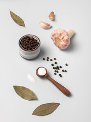 Salt, garlic, pepper, bay leaf. Light gray-blue background. Broth Ingredients.