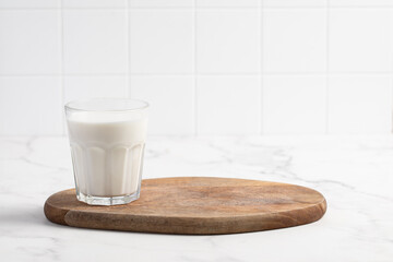 Glass of milk on a light background. Stylish kitchen background.