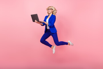 Fototapeta na wymiar Full body photo of pretty excited lady jumping use netbook coworking isolated on pink color background