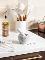 Marble mortar with pestle. Stylish bright kitchen in the background.