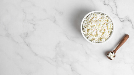 Cottage cheese in a bowl on a light background. Marble background.