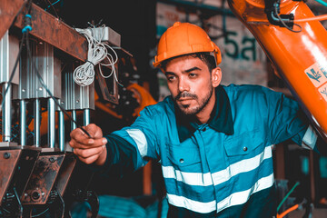 Male engineer controls set and maintenance of the robotic arm of the industrial robotic arm...