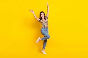 Fototapeta na wymiar Full length photo of cheerful pretty woman dressed vintage flower print blouse dancing rising arms isolated yellow color background
