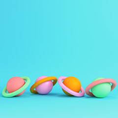 Colorful cartoon style planets with rings on bright blue background in pastel colors. Minimalism concept