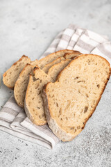 Fresh bread with a crispy crust on a wooden board. Sliced ​​bread. Napkin.