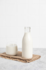 Bottle of milk, glass of milk. Modern white kitchen.