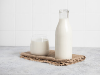 Bottle of milk, glass of milk. Modern white kitchen.