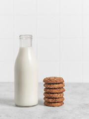 Bottle of milk, oatmeal cookies. Light background. Napkin. 