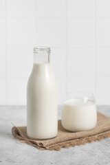 Bottle of milk, glass of milk. Modern white kitchen.