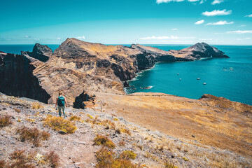 Sporty woman hikes along hike trail with scenic view on the beautiful foothills of the island. São...