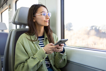Young pensive woman using smartphone in bus