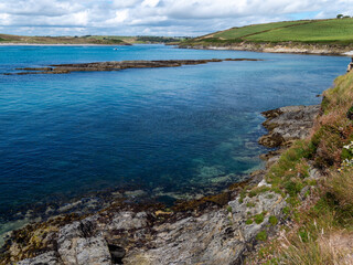 Fototapeta na wymiar The hilly shores of Clonakilty Bay on a sunny summer day. Coast of Ireland, landscape. Blue sea