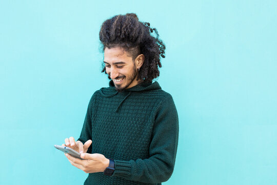 Cheerful black man using smartphone