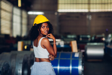 Portrait African American women worker standing in factory industry workplace. Female worker posing confidently while standing in factory workshop