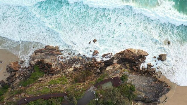 Aerial top down view over Maimi Headland and lookout, following the rocky coastline below back to the beach. Gold Coast, Australia.
