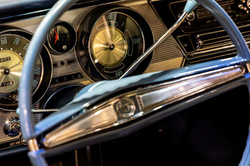 Classic american car dashboard. Steering wheel rim visible. Natural patina related to the age of...