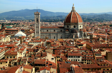 Panoramic view of the historic part of the city of Florence (Italy) with the Cathedral Cattedrale di Santa Maria del Fiore in the center of the photo against the background of the mountains