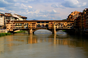 Fototapeta na wymiar Photo of a view of the Ponte Vecchio arch bridge with houses across the Arno river in the historic center of Florence, Italy