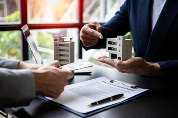Real estate agent holding hands to client to sign agreement on buying or selling house in contract dealing with real estate agent helping client to sign contract documents at desk, insurance concept - obrazy, fototapety, plakaty