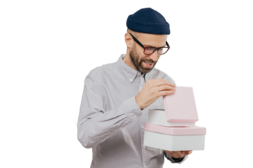 Young man in glasses celebrates, opens gift box on white background, holiday and special occasion concept