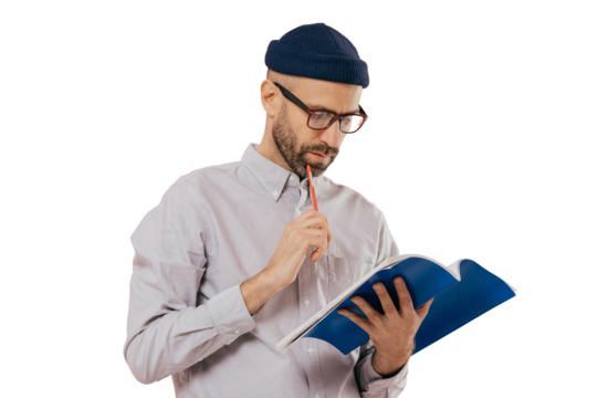 "Author notes in book, dark bristle, holds pencil, attentive gaze, isolated on white wall."