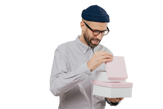 Young man in glasses celebrates, opens gift box on white background, holiday and special occasion concept