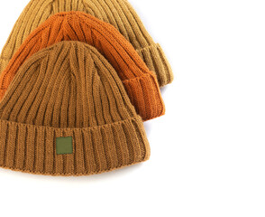 Set of children's warm hats of beige mustard ginger color for spring and autumn knitted isolated on a white background top view
