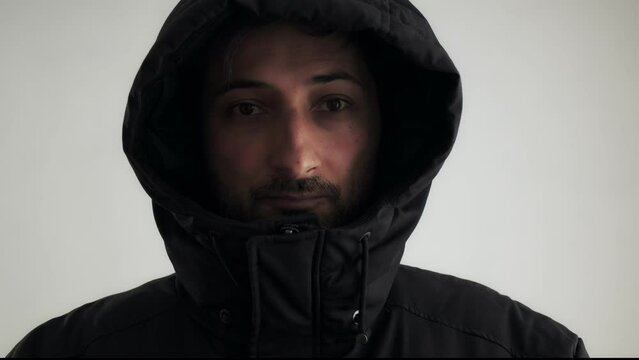 A man of Arab appearance in a black jacket with a hood pulled down over his eyes. Incognita. Identity concealment