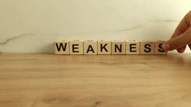 Word weakness made from wooden blocks. Disadvantage, education concepts